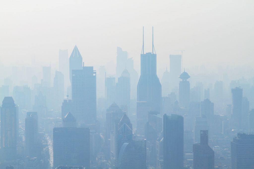 imagem de uma cidade por trás de uma névoa de poluição, que sugere a presença de co2 no ar